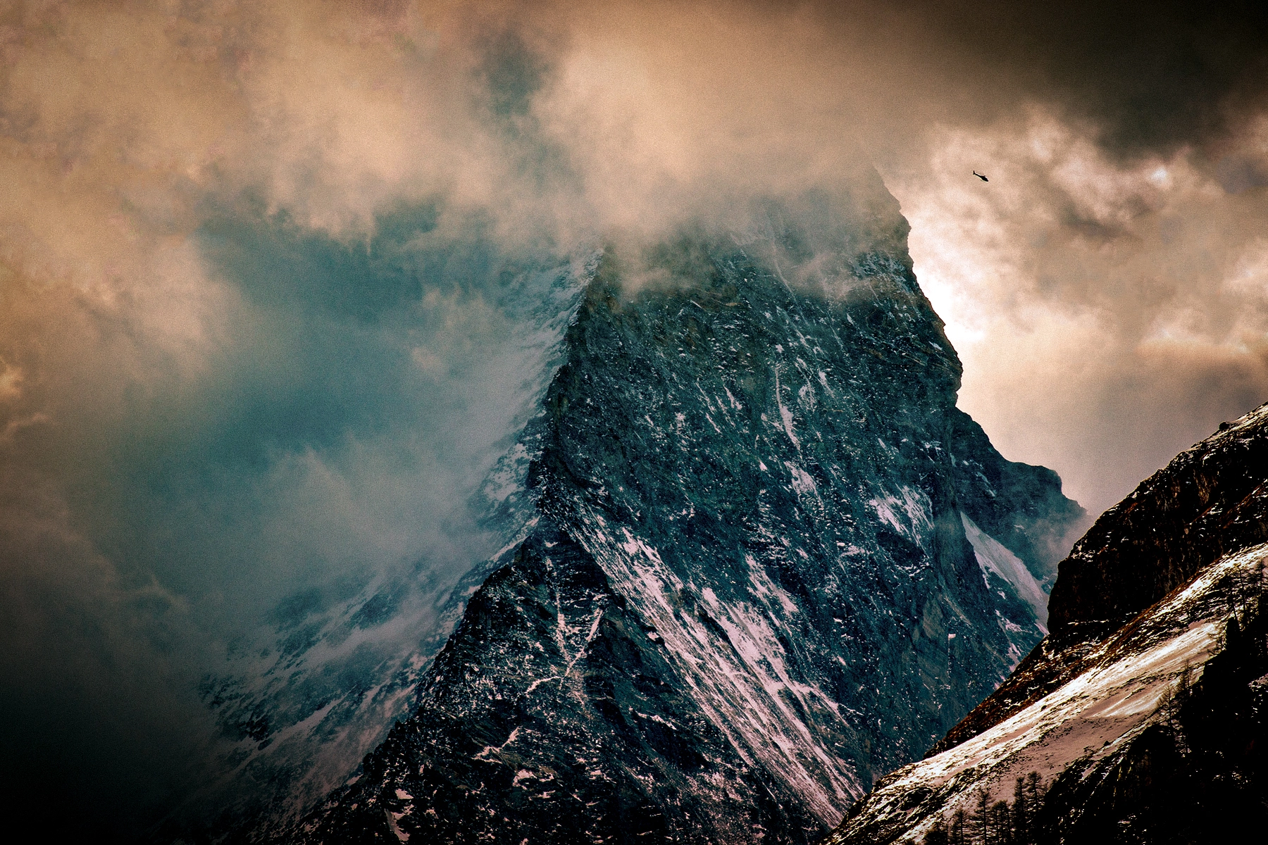 A helicopter seems tiny against the magnitude of the Matterhorn